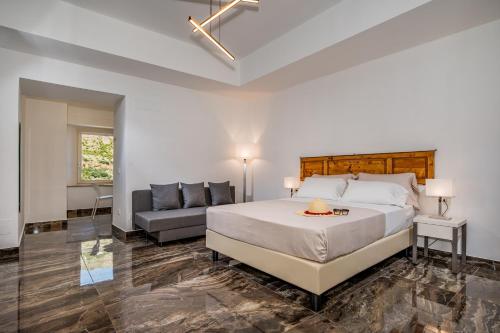 een slaapkamer met een groot bed en een bank bij Suite Altamarea "Sea View Studios" in Castellammare del Golfo