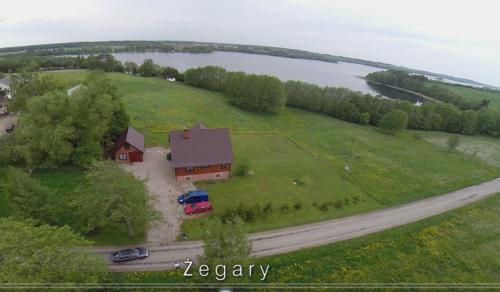 an aerial view of a house on a field with a road at Domek Żegary in Sejny