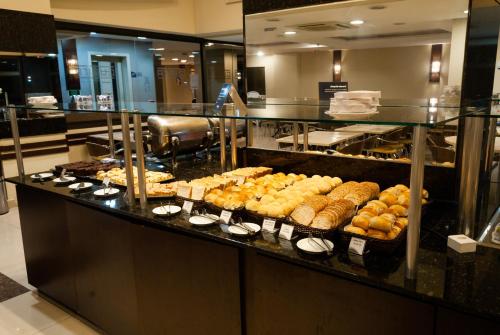 a buffet line with various types of pastries and bread at Master Curitiba Hotel - 1,6 km do Estádio Couto Pereira - Show in Curitiba