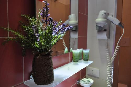 サン・ヴィート・ロ・カーポにあるB&B Jasminのバスルーム(紫色の花が咲く洗面台付)
