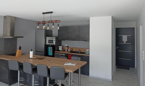une cuisine avec une table et des chaises en bois dans l'établissement Maison Jun, à Josse