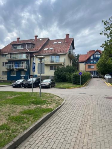 a street with cars parked in front of some buildings at Nida Oasis Apartment in Nida