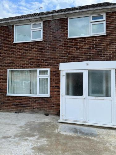 a brick building with two windows and a white garage at Good priced Accommodation in Hayes in Northolt