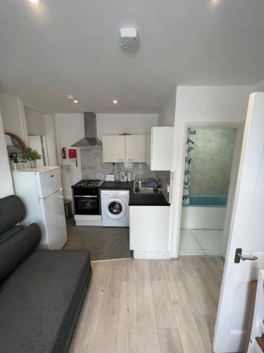 a kitchen with white appliances and a couch in a room at Miles 4floor in London