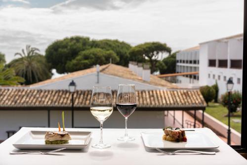 two glasses of white wine on a table with a view at Parador de Mazagón in Mazagón