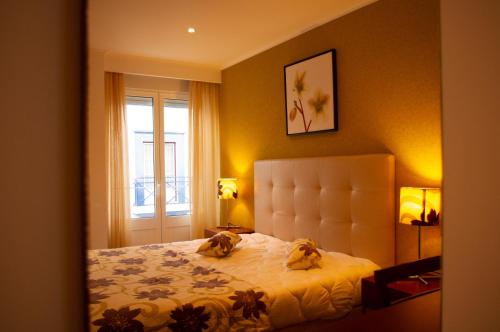 two dogs sitting on a bed in a bedroom at Apartamentos Vila Nova in Vila Nova de Milfontes
