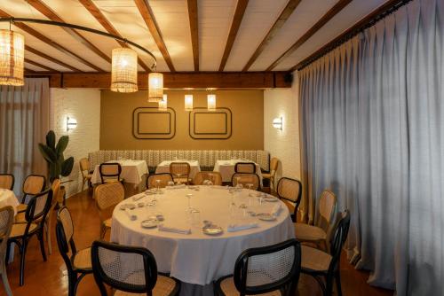 a dining room with a white table and chairs at Parador de Mazagón in Mazagón