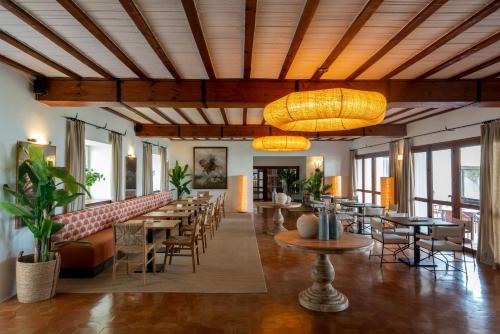 a restaurant with tables and chairs and a large ceiling at Parador de Mazagón in Mazagón