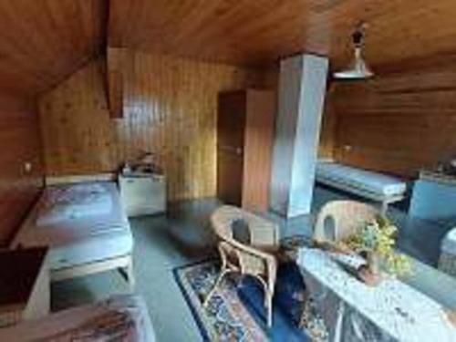 - un salon avec une cuisinière, un canapé et des chaises dans l'établissement Chalupa Kruh, à Doksy