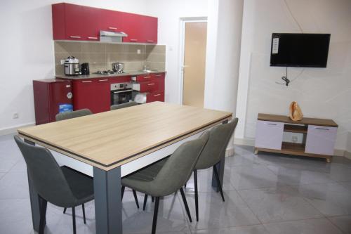 a kitchen with a wooden table and chairs at Hary's Aparthotel in Toliara