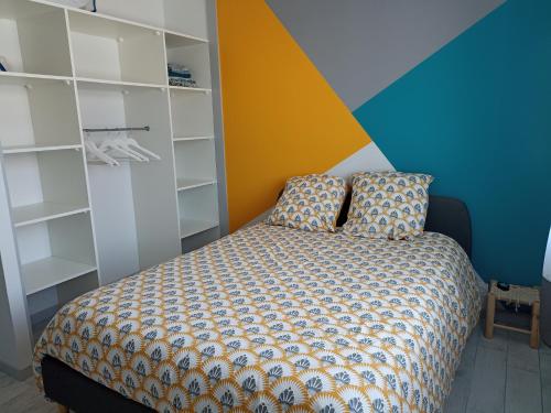 - une chambre avec un lit et un mur coloré dans l'établissement Maison Jun, à Josse