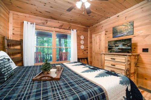 ein Schlafzimmer mit einem Bett und einem Fenster in einer Hütte in der Unterkunft Great Smoky Mountains Cabin near Cashiers, NC! in Glenville