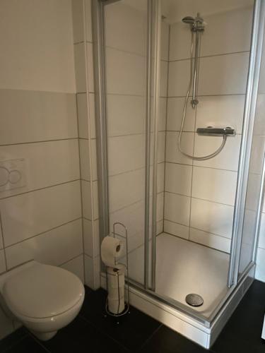 ein Bad mit einer Dusche und einem WC in der Unterkunft Schönes einfaches Zimmer im belebten Zentrum in Wilhelmshaven