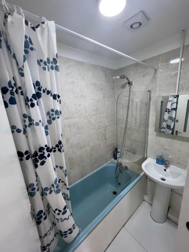a bathroom with a blue bath tub and a sink at Miles 4floor in London