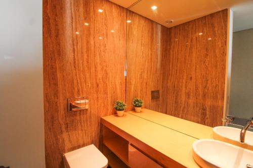 a bathroom with wooden walls and a sink and a toilet at Ocean View Luxury Apartment in Vila Nova de Gaia