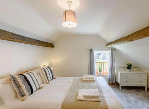 a large white bed in a room with a window at Magpie cottage in Pickering