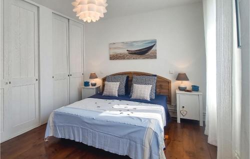 - une chambre dotée d'un lit avec des draps bleus et un lustre dans l'établissement Nice Home In Marennes With Private Swimming Poo,,,, à Marennes