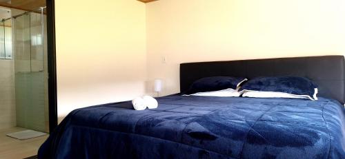 a bedroom with a blue bed with towels on it at Apartamento - ApartaSuite ARGUS in Paipa