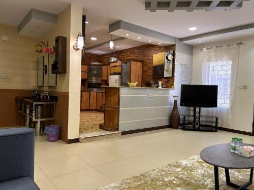 ein Wohnzimmer mit einer Küche und einem TV in der Unterkunft ليلتنا1 in Ha'il