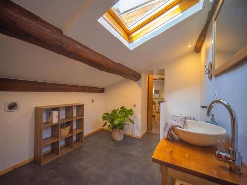 a bathroom with a sink and a skylight at By les Climats - La Grande Rue in Perrigny-lès-Dijon