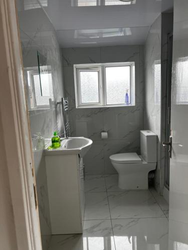 uma casa de banho branca com um lavatório e um WC em Good priced double bed in Hayes em Northolt