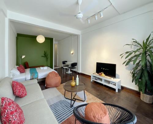 a living room with a bed and a tv at SANT Bangkok at Khaosan Road in Bangkok