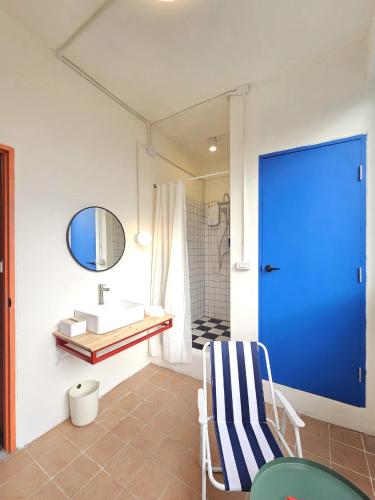 a bathroom with a sink and a blue door at SANT Bangkok at Khaosan Road in Bangkok