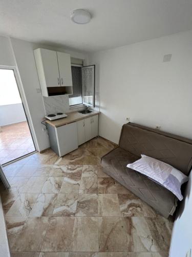 a kitchen with a couch in the middle of a room at Apartments Beho in Ulcinj