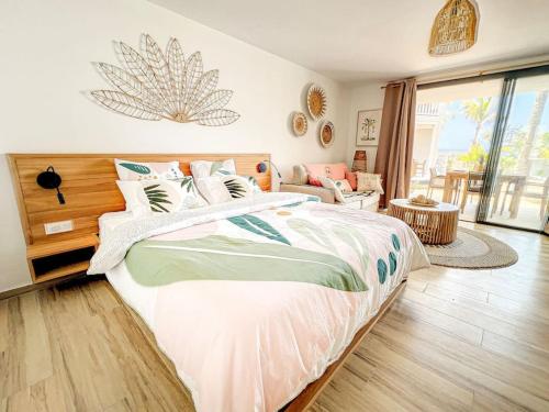 a bedroom with a large bed and a living room at Hello Summer large studio on Orient Bay beach in Orient Bay
