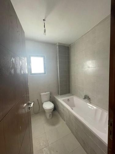 La salle de bains est pourvue d'une baignoire, de toilettes et d'un lavabo. dans l'établissement Ikamet Lilian, à Tabarka