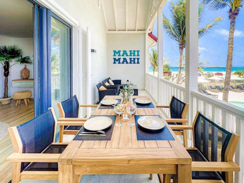 a dining room with a wooden table and chairs at Mahi Mahi direct access to Orient Bay beach in Orient Bay