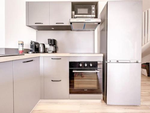 a kitchen with white cabinets and a stainless steel oven at Mahi Mahi direct access to Orient Bay beach in Orient Bay