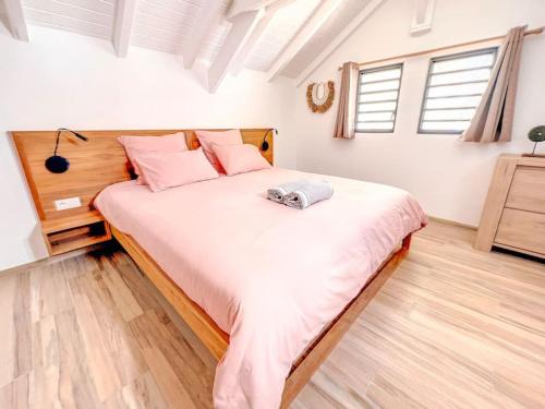 a bedroom with a large bed with pink pillows at Mahi Mahi direct access to Orient Bay beach in Orient Bay