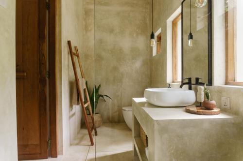 a bathroom with a white sink and a mirror at The Nook RESORT in Devinuwara