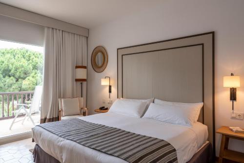 a hotel room with a bed and a balcony at Parador de Mazagón in Mazagón
