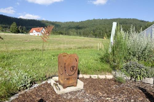 a wooden statue in a garden in a field at SchwarzWild - Ferienwohnung und Ferienzimmer in Baiersbronn
