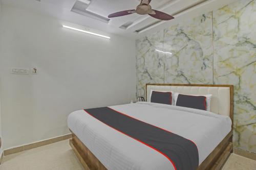 Schlafzimmer mit einem Bett und einem Deckenventilator in der Unterkunft Vinayaka Luxury Stays in Warangal