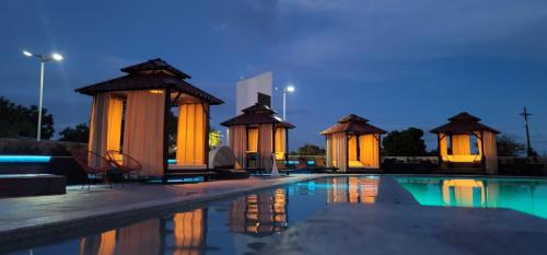 una fila de cenadores junto a una piscina por la noche en Aloft Ponce Hotel & Casino en Ponce