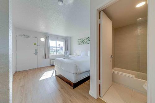 1 dormitorio con 1 cama y bañera en una habitación en Travel Lodge by Wyndham 10 min from Disney, en Kissimmee