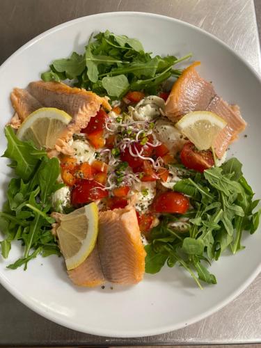 a white plate with a salad with fish and vegetables at Hotel Sonnenhügel in Bad Bevensen