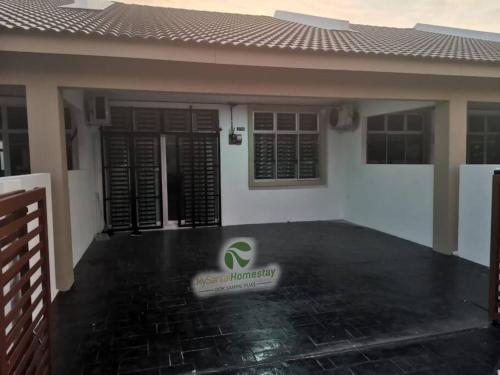 a house with a sign on the front of it at MySantai Homestay Padang Serai in Padang Serai