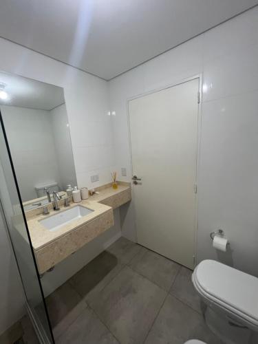 ein Badezimmer mit einem Waschbecken, einem WC und einem Spiegel in der Unterkunft Apartamento Mirador de la Viña. in Salta