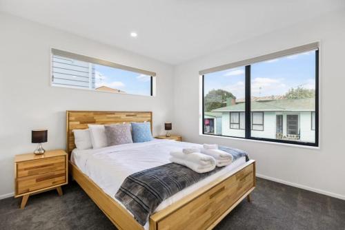a bedroom with a bed and a large window at Modern Family Townhouse in Mt Roskill, Auckland in Auckland