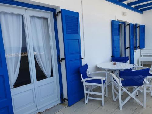 a blue and white room with a table and chairs at Rodothea and Adams on the Beach, Santorini in Monolithos