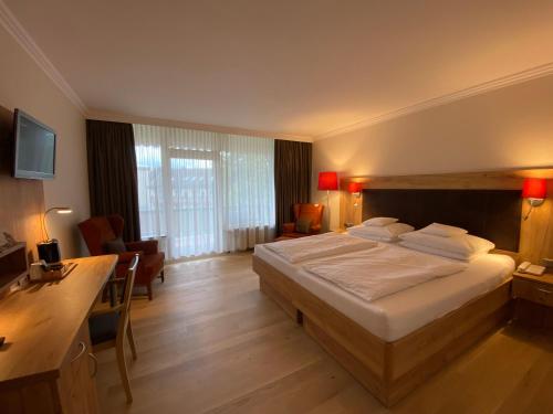 a hotel room with a large bed and a desk at Hotel Sonnenhügel in Bad Bevensen