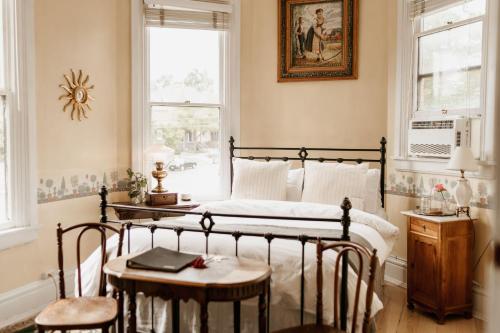 a bedroom with a bed and a table and chairs at Ellerbeck Bed & Breakfast in Salt Lake City