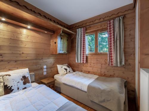 deux lits dans une chambre aux murs en bois dans l'établissement Appartement 2 chambres avec piscine et spa, au pied des pistes à Méribel Village - FR-1-566-37, à Les Allues