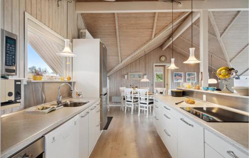 a kitchen with white cabinets and a dining room at 3 Bedroom Cozy Home In Løgstør in Løgsted