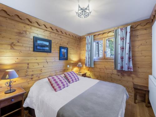 une chambre avec un lit et un mur en bois dans l'établissement Appartement proche des pistes avec piscine, spa et parking couvert à Méribel Village - FR-1-566-50, à Les Allues