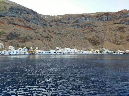 a view of a large body of water with houses at Rodothea and Adams on the Beach, Santorini in Monolithos